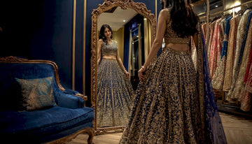 Woman adjusting lehenga outfit in boutique mirror