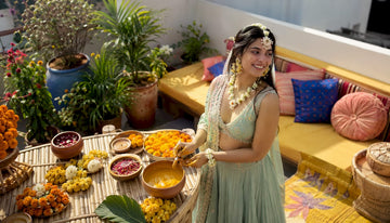 Woman in yellow saree preparing for haldi ceremony outdoors